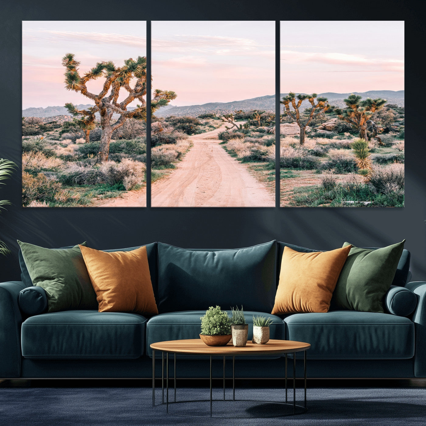A dusty road winding through Joshua Tree National Park, framed by iconic twisted trees and warm desert tones under a soft pastel sky.