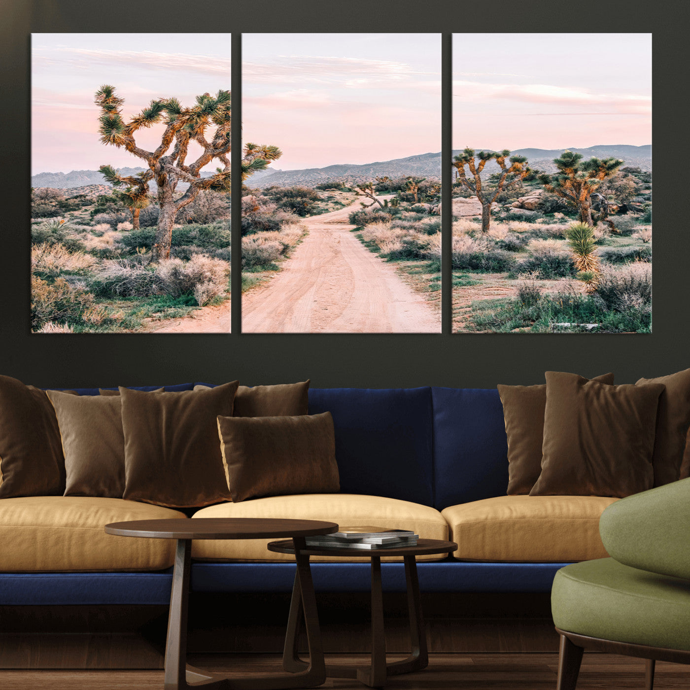A dusty road winding through Joshua Tree National Park, framed by iconic twisted trees and warm desert tones under a soft pastel sky.