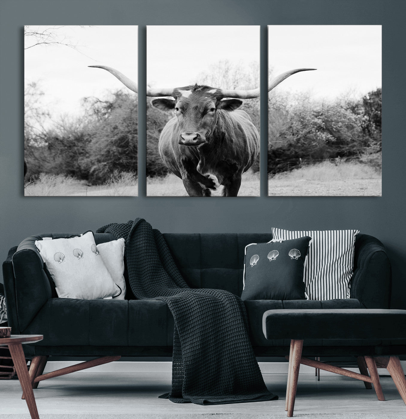 Black and white photo of a longhorn cow in a field, perfect for rustic farmhouse or western-themed interior wall decoration.