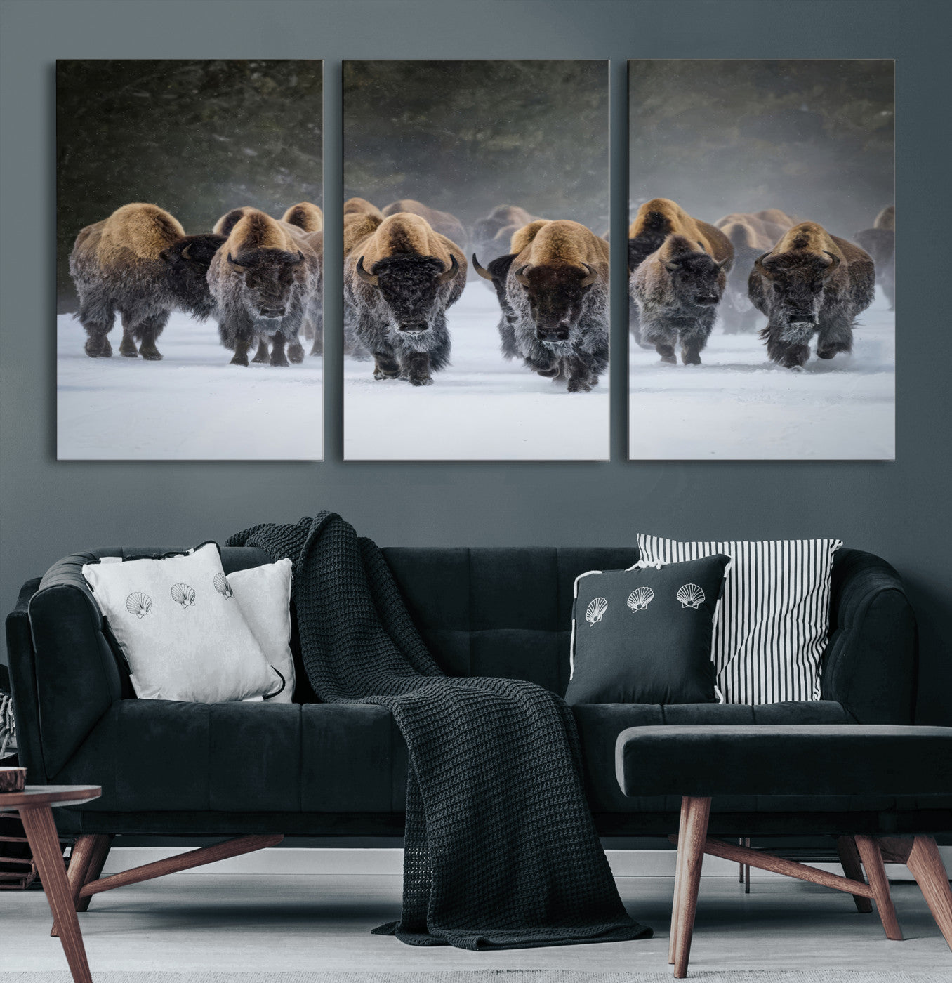 A herd of American bisons walking through deep snow in a forest, evoking a powerful rustic wilderness mood for western-style interiors.