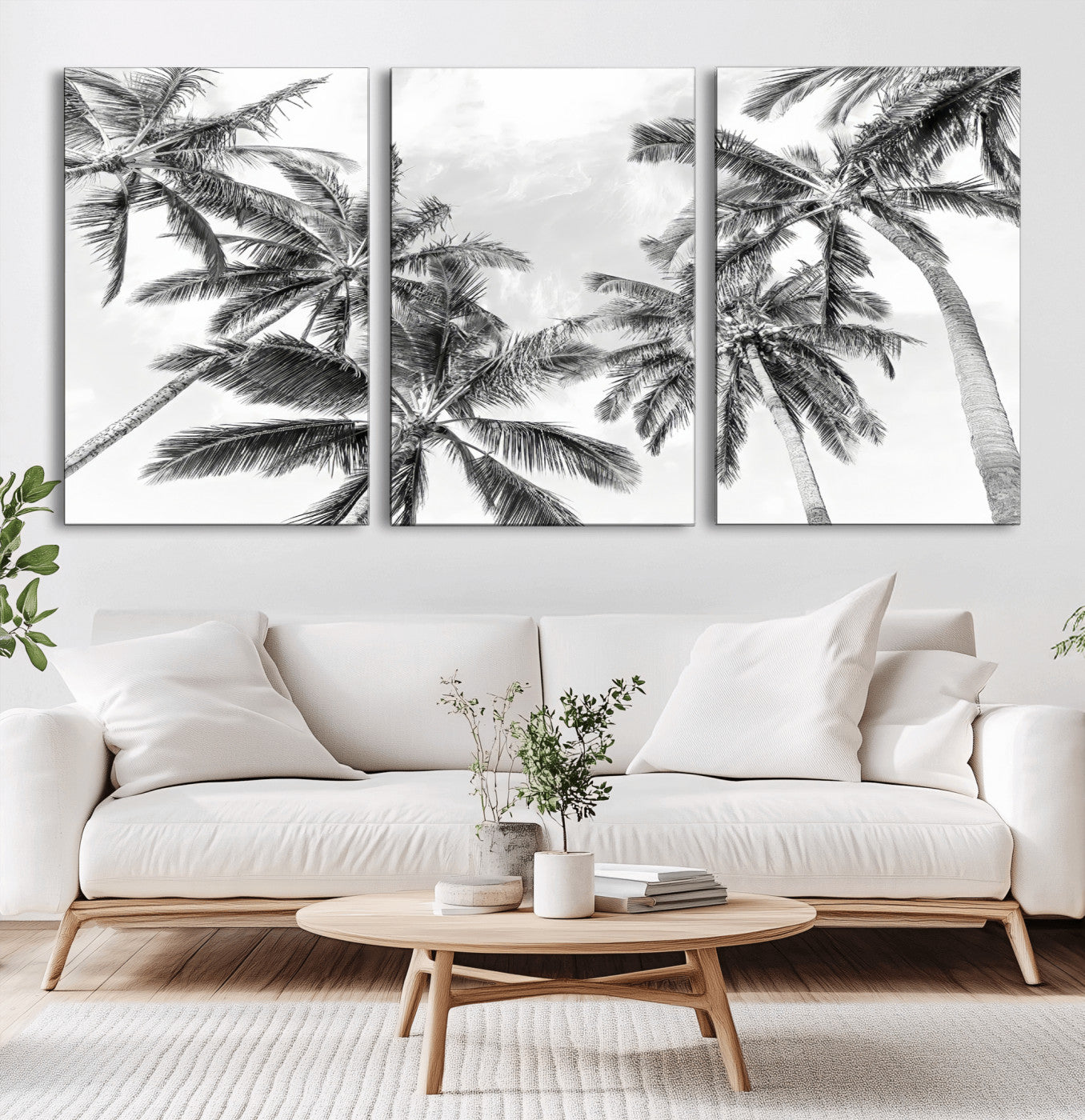 Black and white tropical palm trees viewed from below, swaying gently against a bright sky, creating a serene and elegant coastal atmosphere.