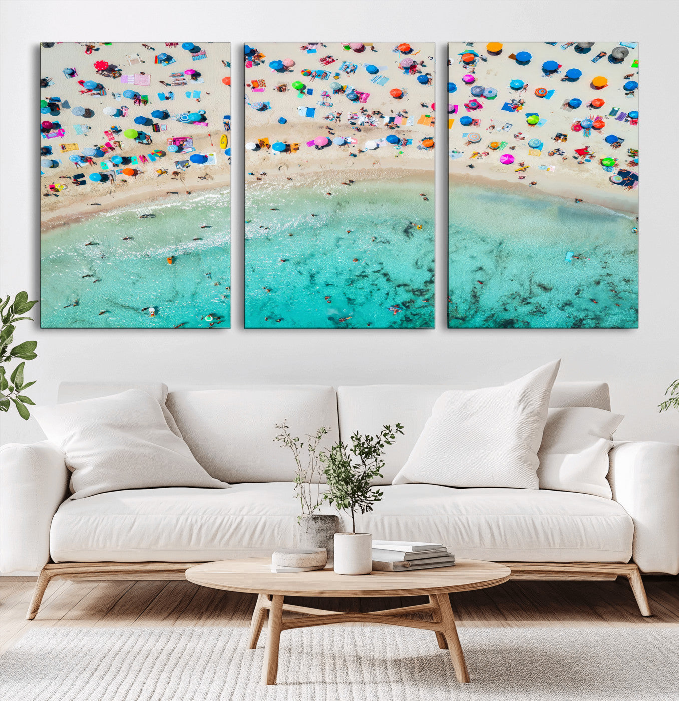 Aerial view of a vibrant beach filled with colorful umbrellas and people enjoying the turquoise ocean, capturing a lively summer vacation scene.