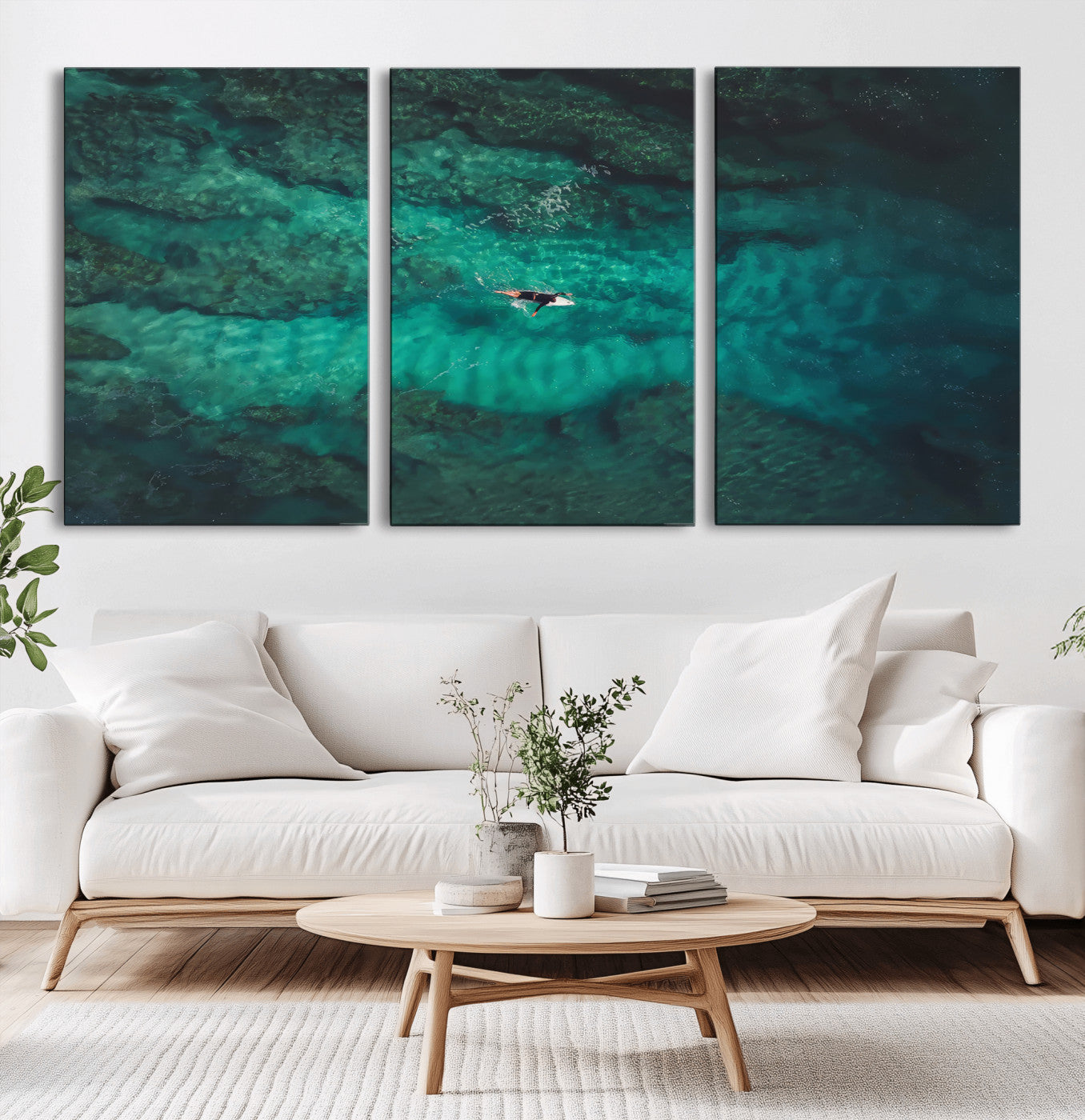 An aerial view of a solo surfer paddling through crystal-clear turquoise waters over a sunlit reef, capturing the beauty and serenity of open water surfing.