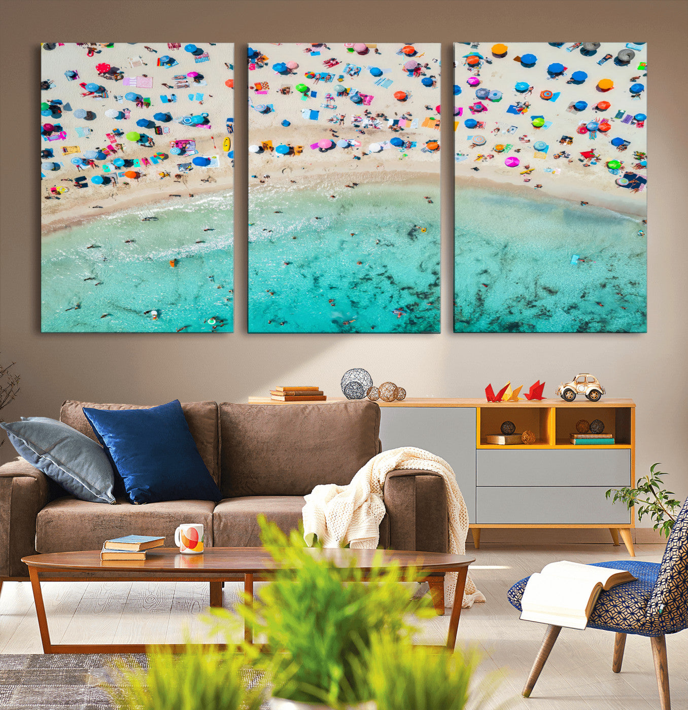 Aerial view of a vibrant beach filled with colorful umbrellas and people enjoying the turquoise ocean, capturing a lively summer vacation scene.