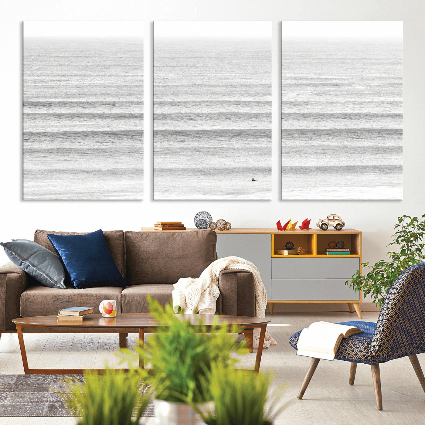 Monochrome photo of a lone surfer in calm layered waves, perfect for minimalist coastal or moody ocean-inspired wall decoration.