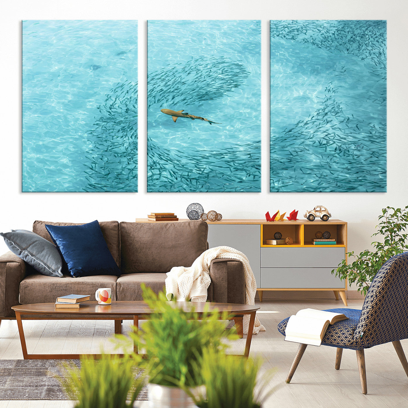 Aerial view of a shark swimming through a swirl of fish in clear turquoise waters, perfect for calm coastal or beach house decor.