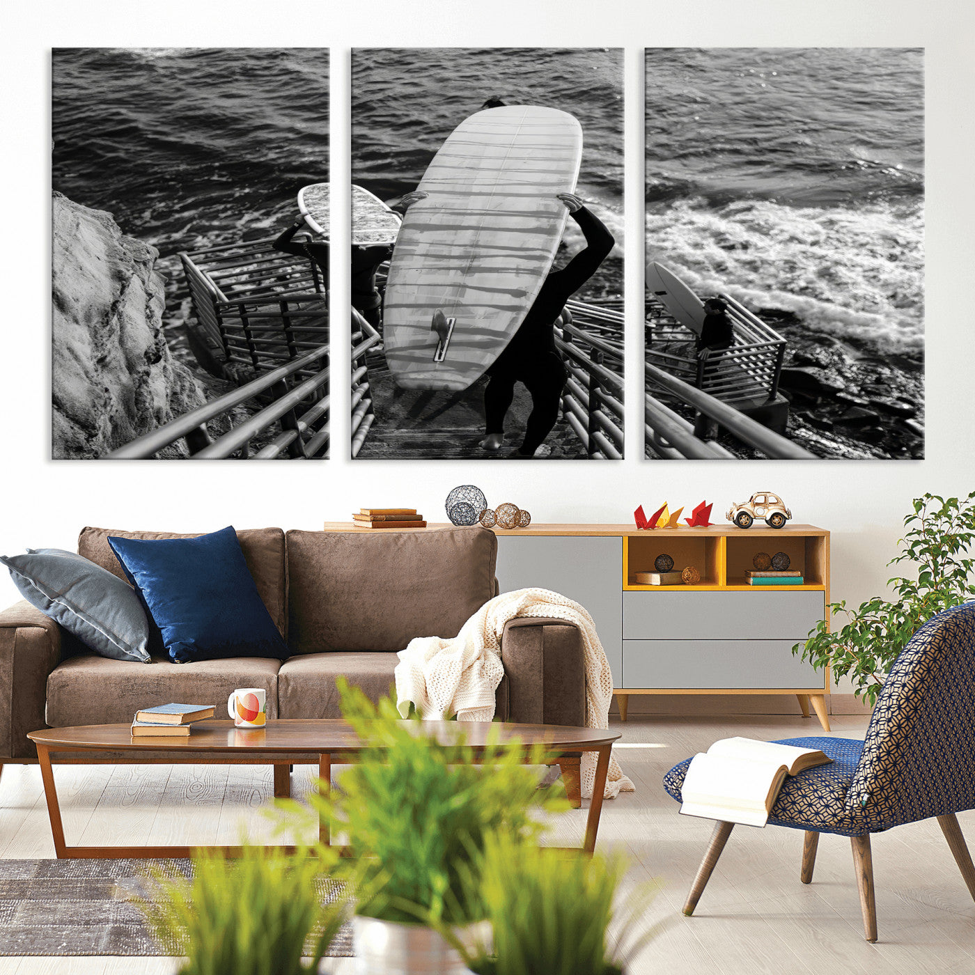 Black and white photo of surfers carrying boards down a rugged cliffside stairway, capturing a bold and adventurous coastal scene.