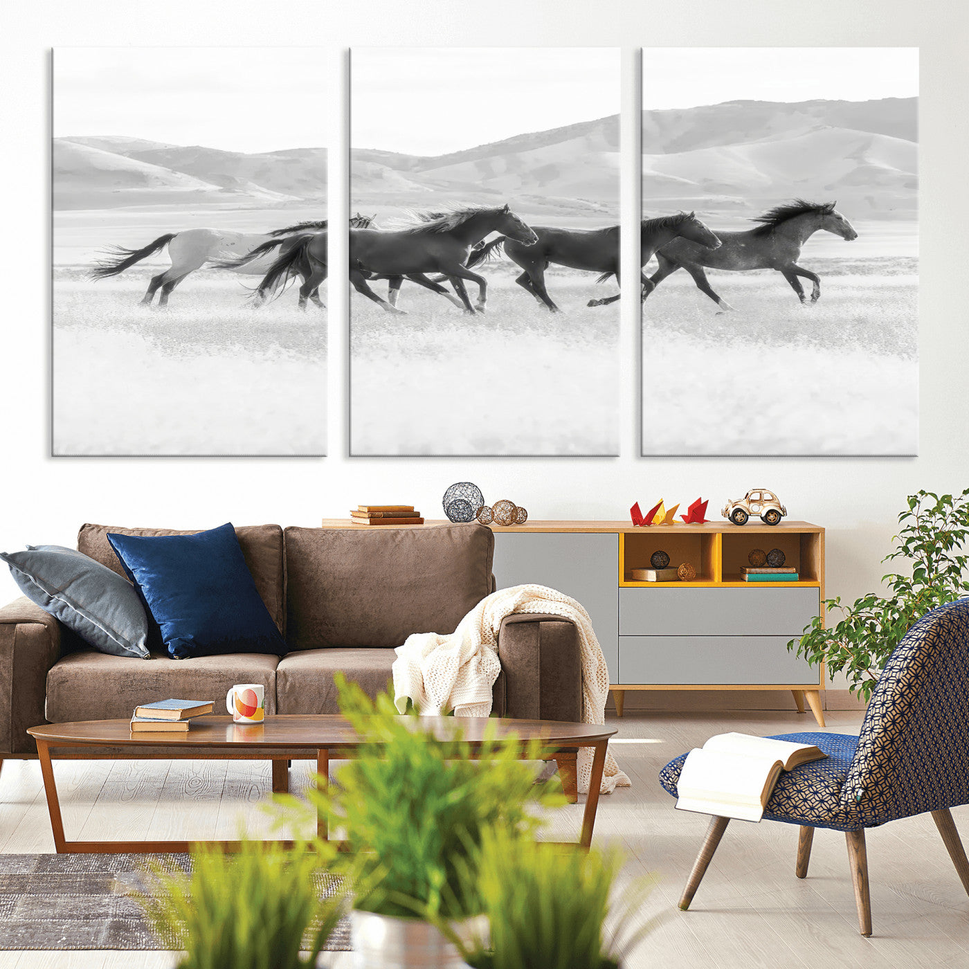 A black and white image of wild horses running freely across an open grassland, capturing the power and beauty of untamed nature in a rustic western setting.