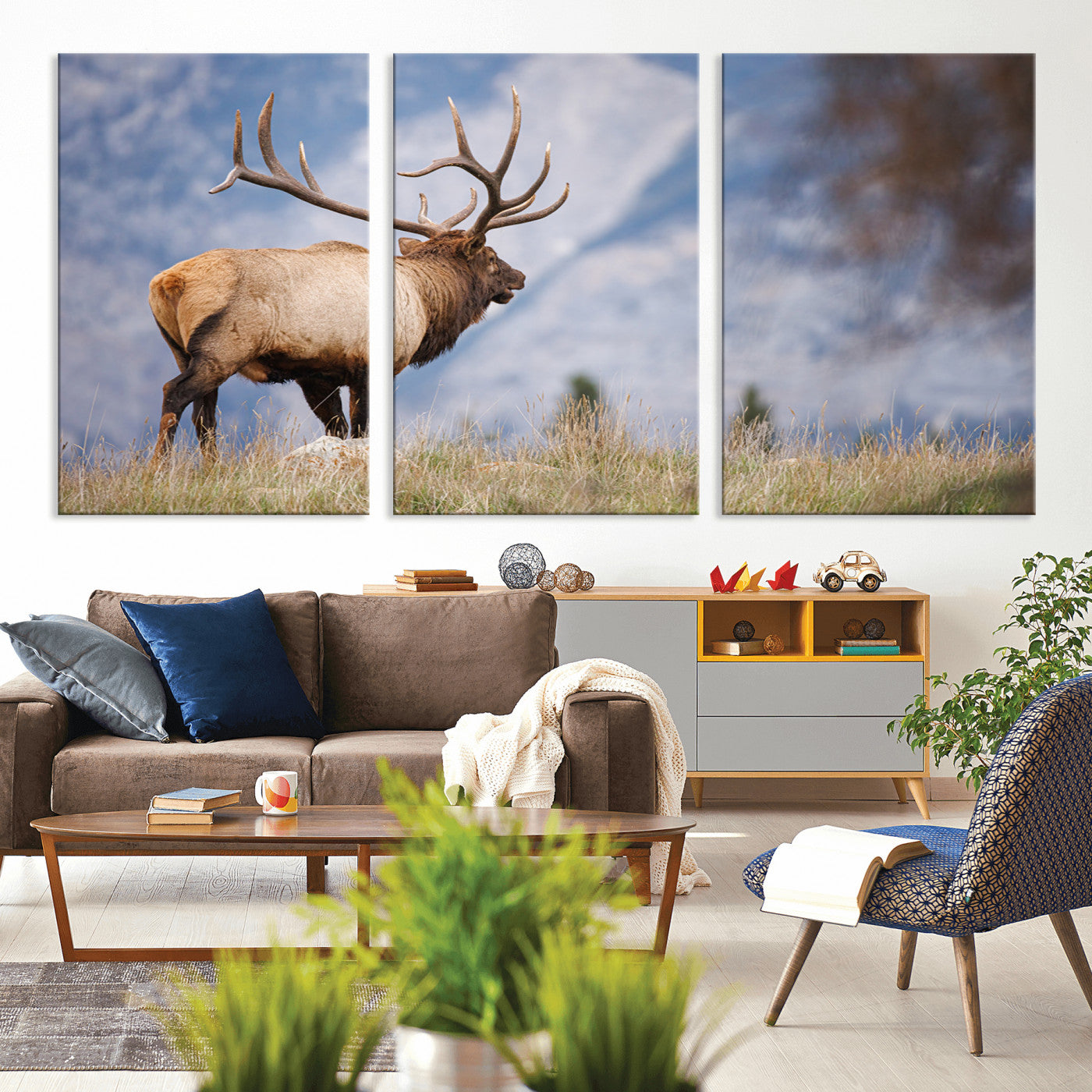 Elk with antlers standing on grass with mountain background, ideal for rustic, cabin, or lodge-inspired wall decor.