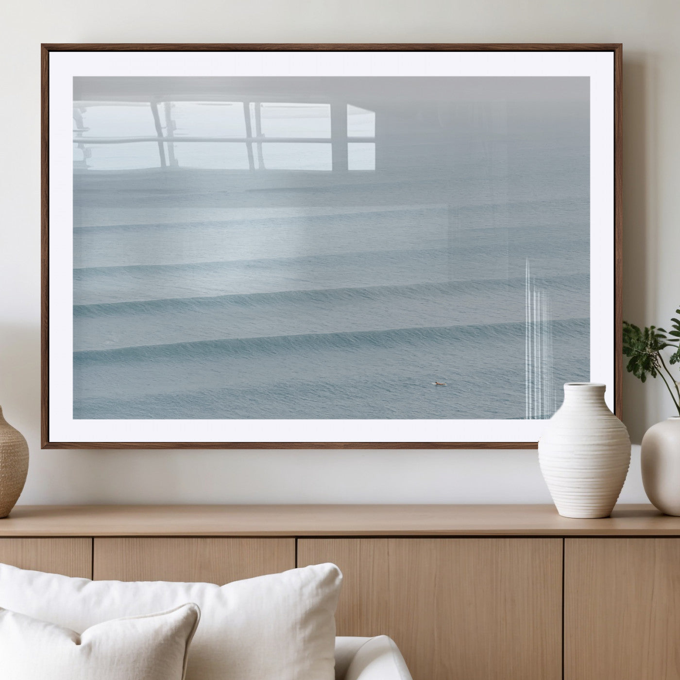 Framed canvas of repeating ocean waves with a distant solo surfer, ideal for minimalist ocean or calm coastal wall decor.
