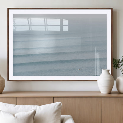 Framed canvas of repeating ocean waves with a distant solo surfer, ideal for minimalist ocean or calm coastal wall decor.