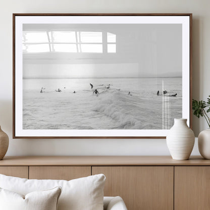 Monochrome photo of surfers riding and waiting on ocean waves, ideal for surf-themed or coastal energy wall decor.