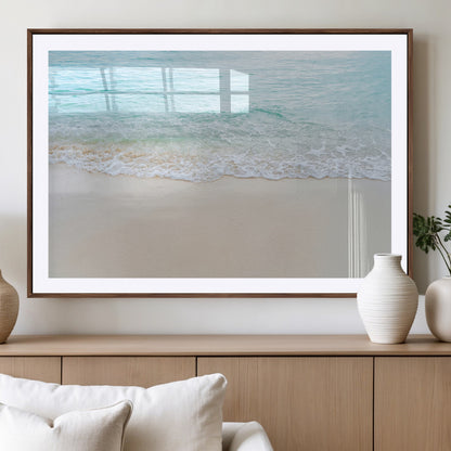 Soft shoreline with gentle aqua waves on smooth sand, ideal for minimalist coastal or pastel ocean-inspired home wall decor.
