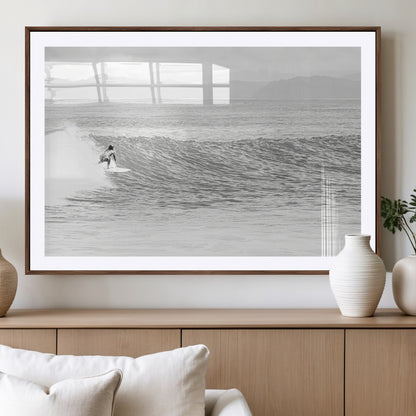 Monochrome photo of a surfer riding a wave with distant mountains, ideal for coastal motion or black and white surf-themed wall decor.