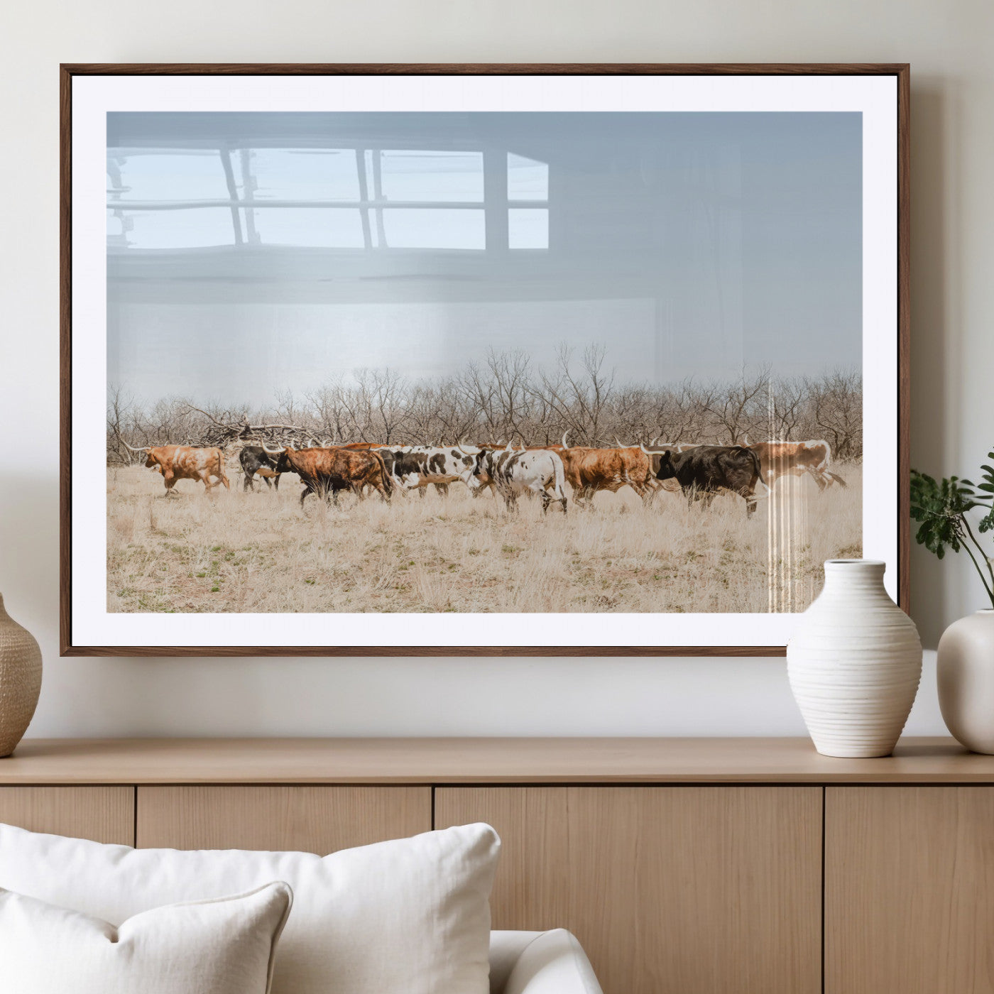 Framed wall art of Texas longhorn cattle walking through a dry, neutral-toned prairie, perfect for rustic farmhouse or western-themed home decor.