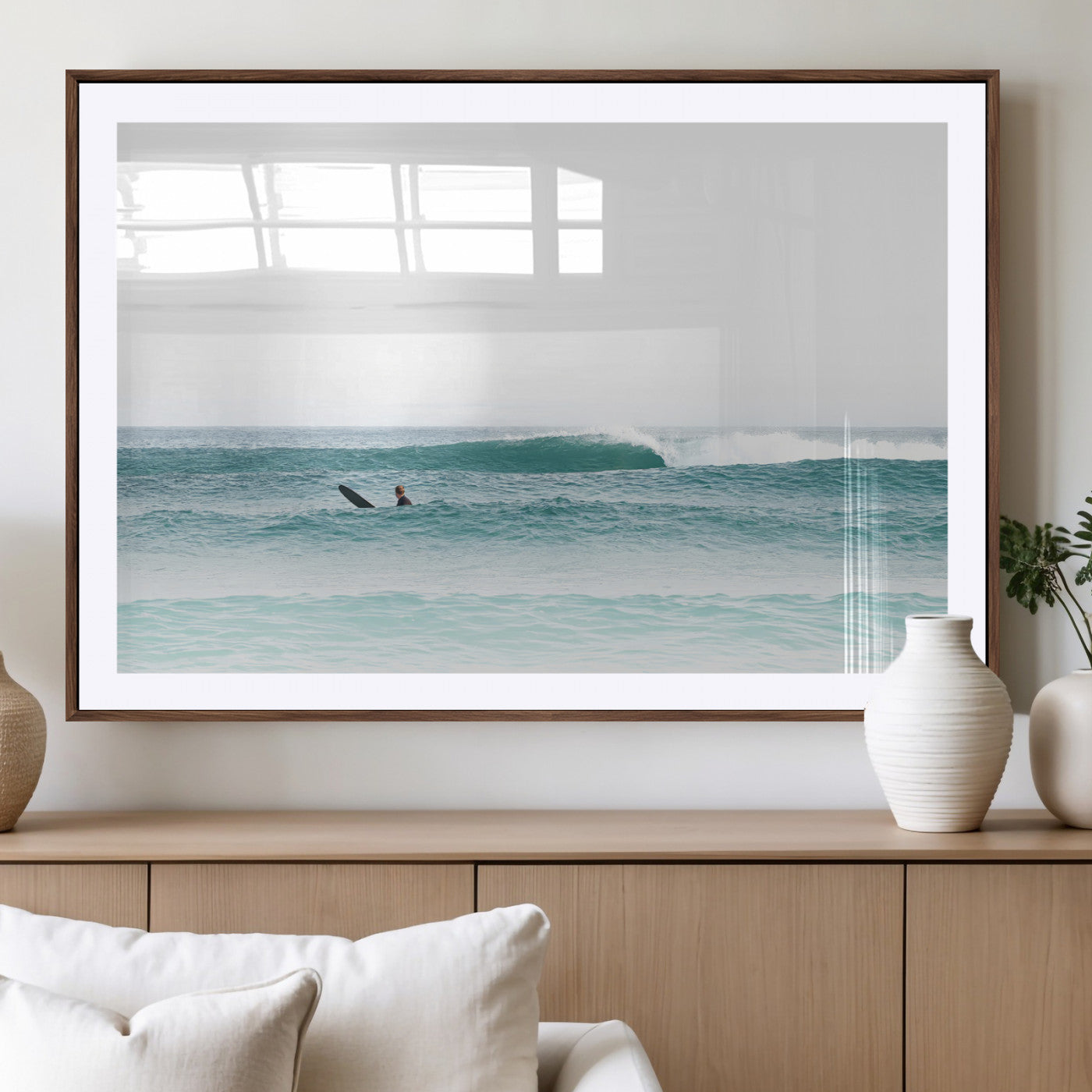 Minimalist photo of a lone surfer on calm aqua waves under bright sky, perfect for Scandinavian coastal or serene ocean-inspired home decor.