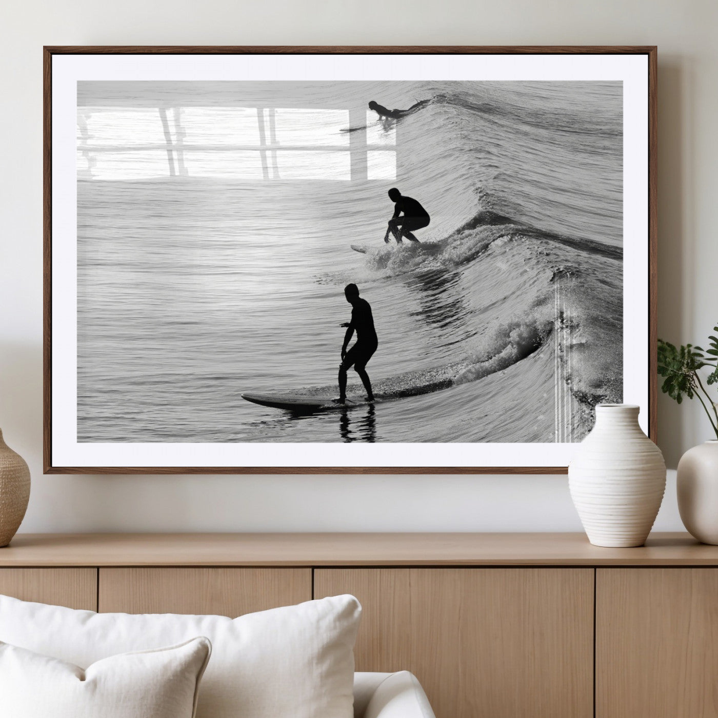 Black and white photo of surfers riding waves in a moody, high-contrast scene, ideal for modern coastal or surf-inspired home decor.