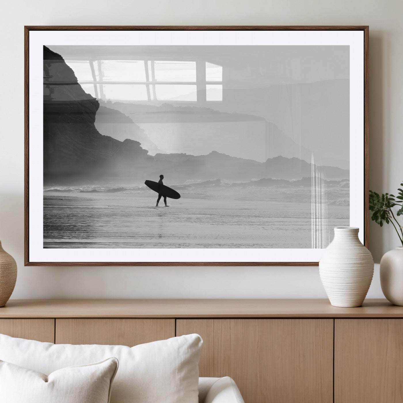 A lone surfer walking along a misty beach with cliffs in the background, carrying their board, capturing a serene and minimal ocean moment.