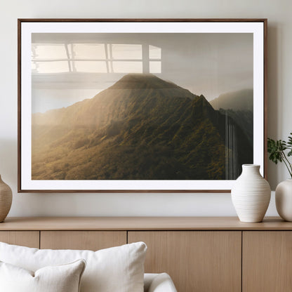 Sunlit mountain peak with mist rolling over its rugged slopes, bathed in golden light, creating a warm and tranquil nature-inspired scene.