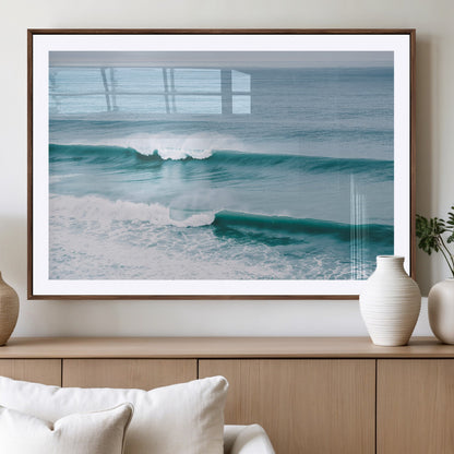 Powerful ocean waves rolling towards the shore, their turquoise hues blending with white sea foam under an open horizon, capturing the essence of the ocean's movement.