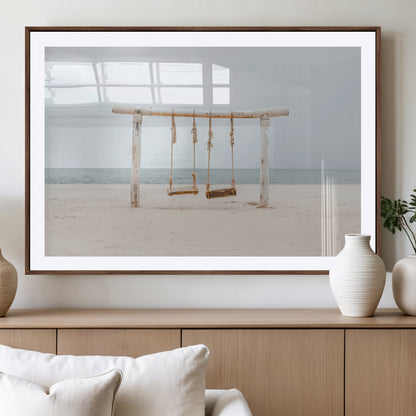 A rustic wooden beach swing stands on a serene sandy shore with an ocean horizon in the background, creating a tranquil and dreamy coastal escape.