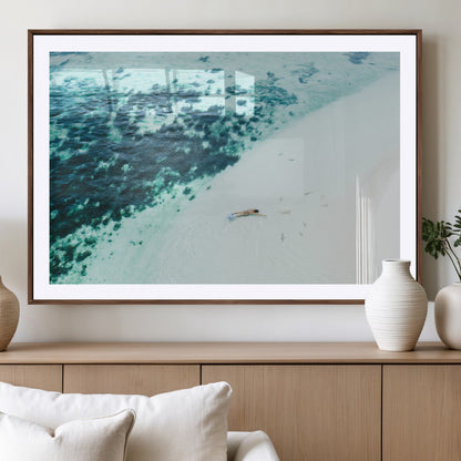 Canvas featuring an aerial view of a swimmer in shallow turquoise waters with coral patterns, ideal for tropical coastal home decor.