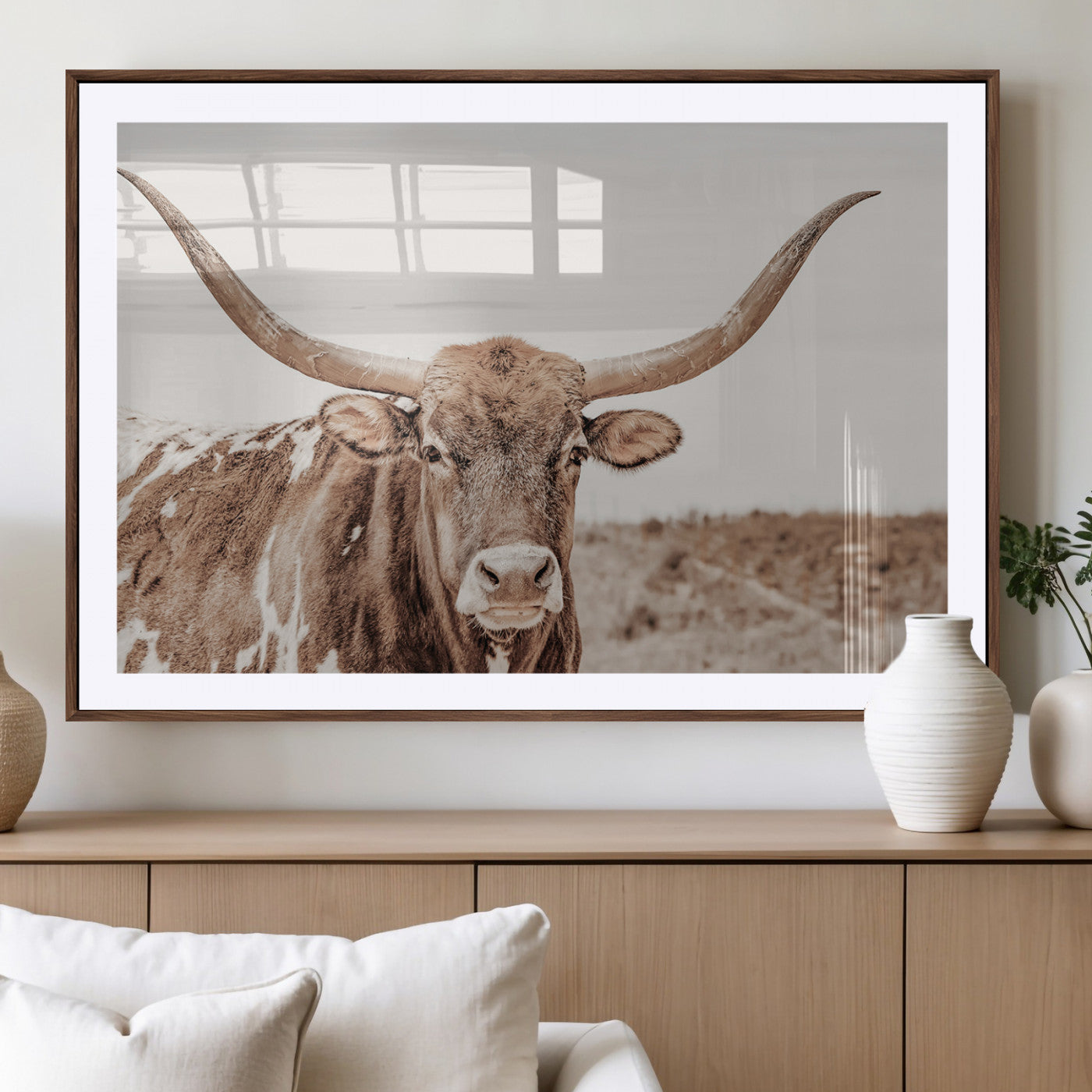 A longhorn cow in soft beige desert tones, standing calmly in open land, perfect for neutral western or rustic farmhouse interiors.
