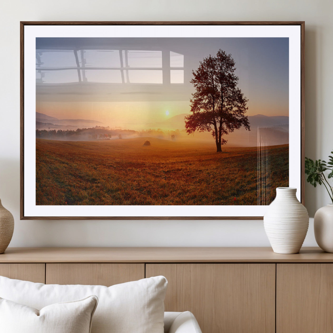 A tranquil landscape at sunrise with a mist-covered field and a lone tree, creating a peaceful and natural atmosphere.