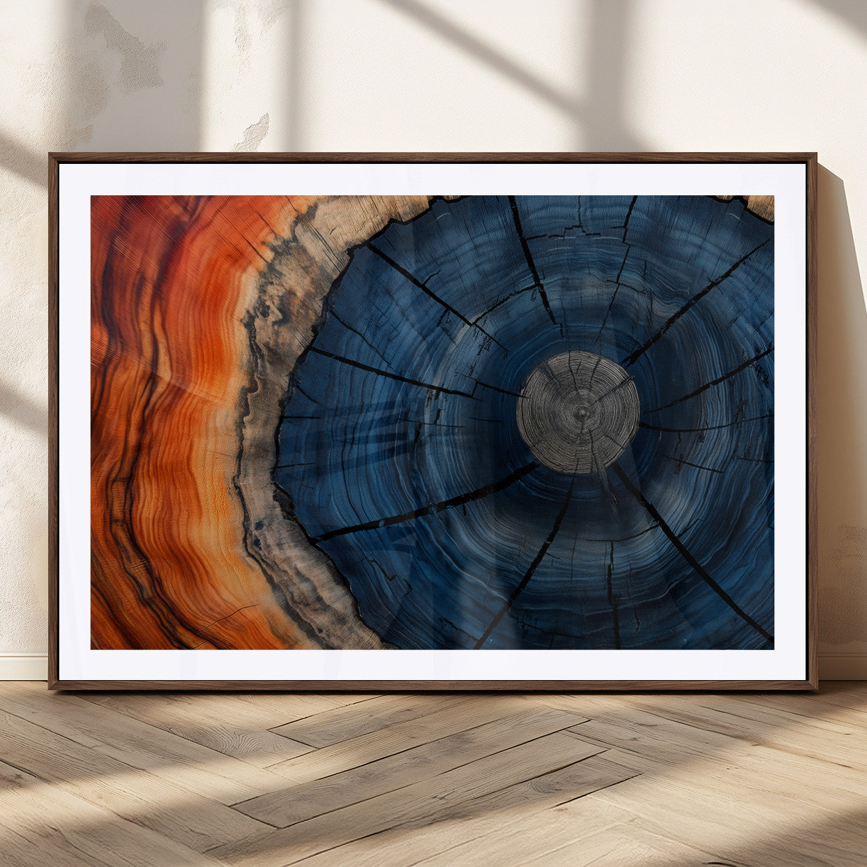 A captivating close-up of a tree trunk, showcasing its concentric rings in rich shades of blue, orange, and brown, highlighting the organic patterns of natural wood.