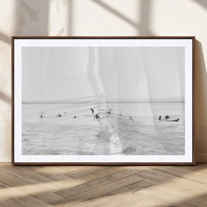 Monochrome photo of surfers riding and waiting on ocean waves, ideal for surf-themed or coastal energy wall decor.