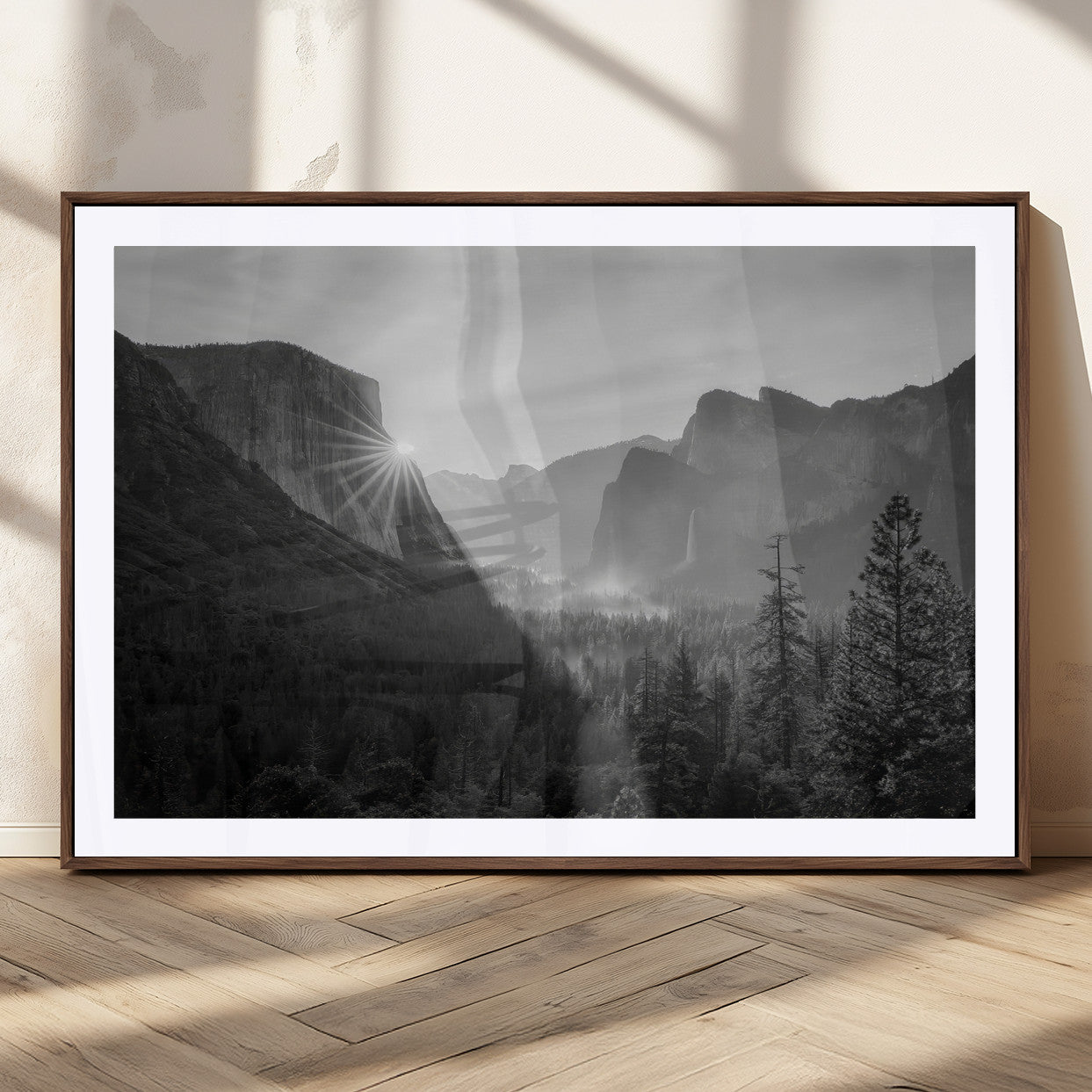 Black and white landscape of Yosemite with sun rays peeking over El Capitan, ideal for moody nature or modern rustic decor.