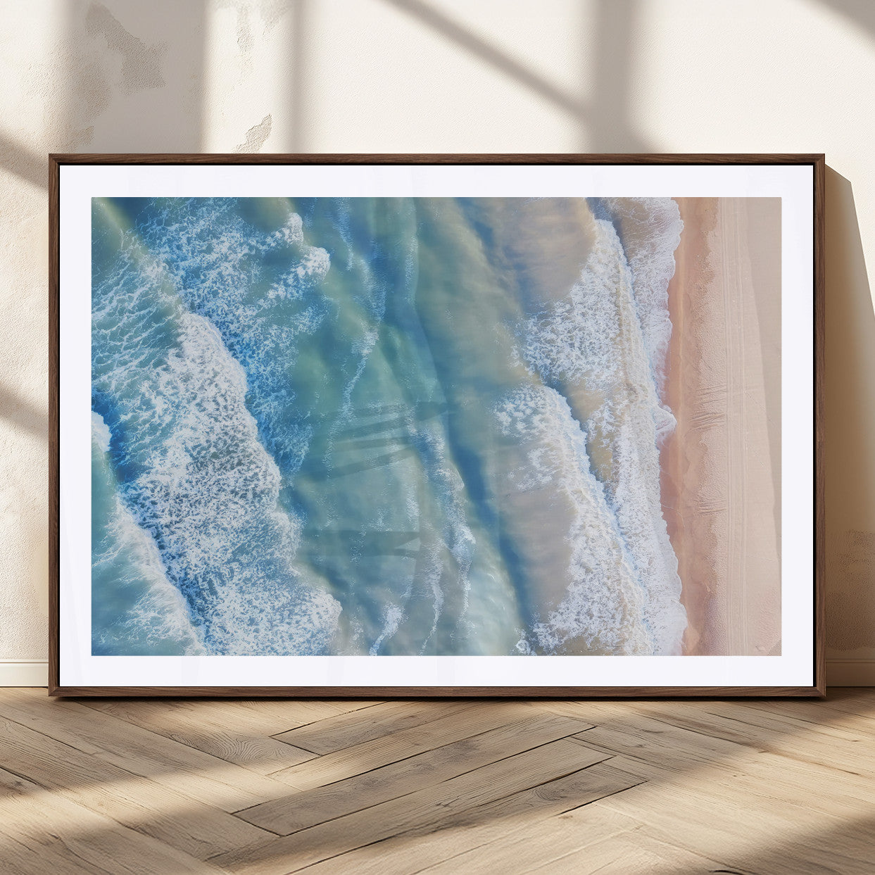 Aerial photo of soft blue waves meeting sandy shore, perfect for modern coastal or beach-themed decor with a light and tranquil aesthetic.