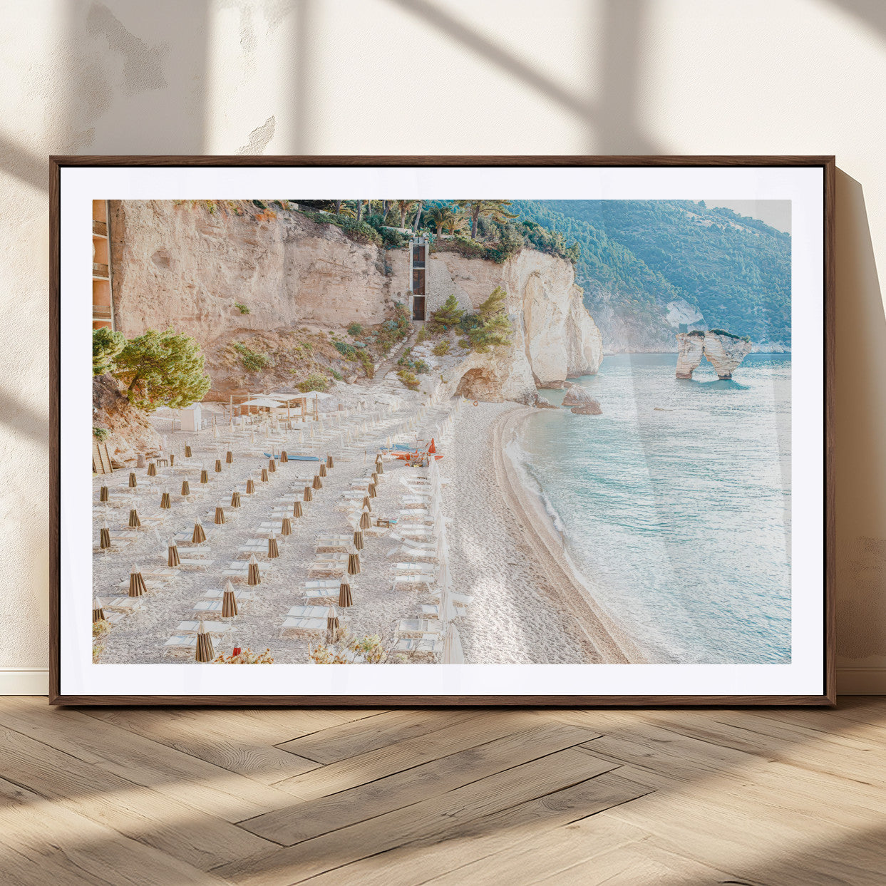 Wall art of a calm Mediterranean beach with rows of sun loungers and umbrellas in soft pastel tones, perfect for light coastal or vacation-themed decor.