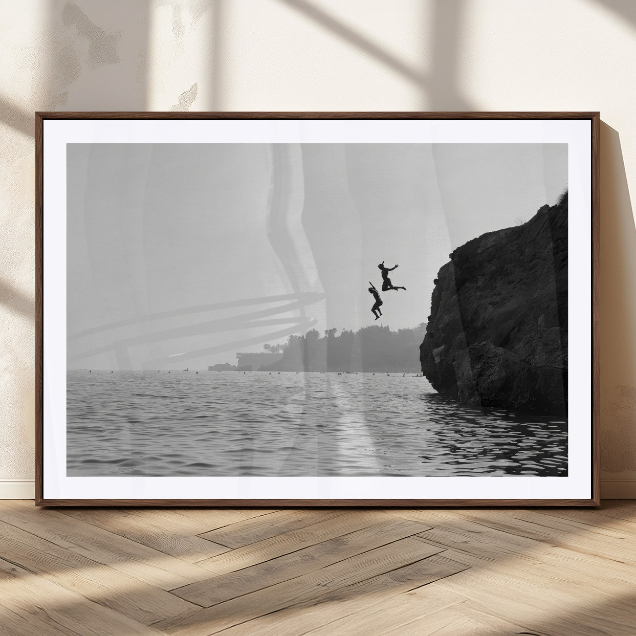 Black and white canvas of two figures cliff jumping into the sea, captured with moody tones, ideal for modern coastal or adventure-themed home decor.   2/2