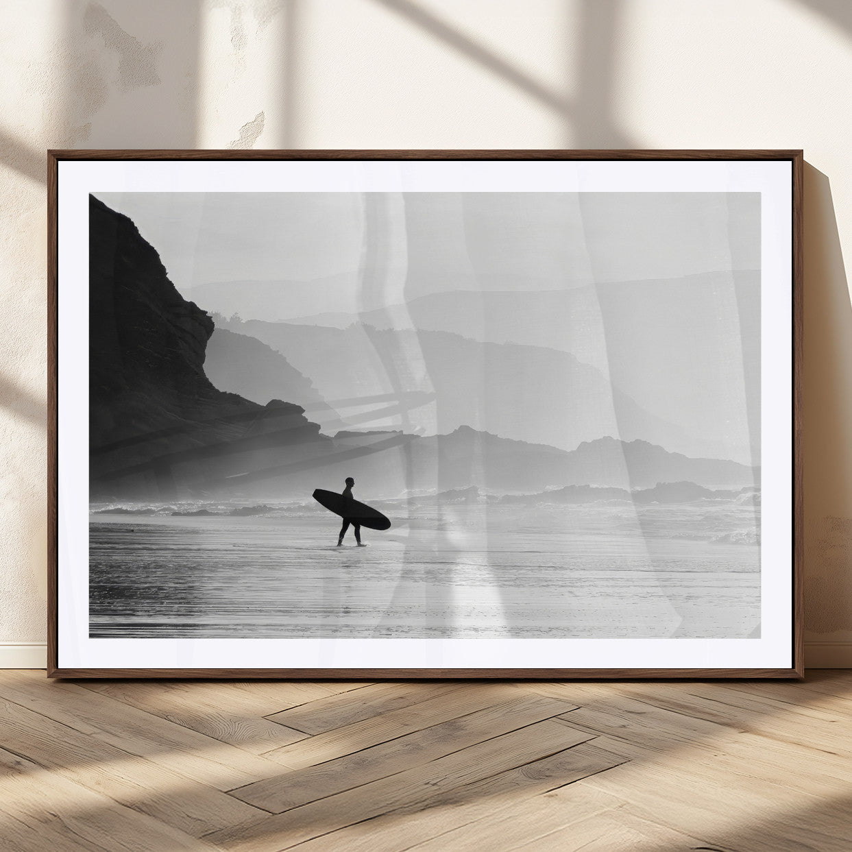 A lone surfer walking along a misty beach with cliffs in the background, carrying their board, capturing a serene and minimal ocean moment.
