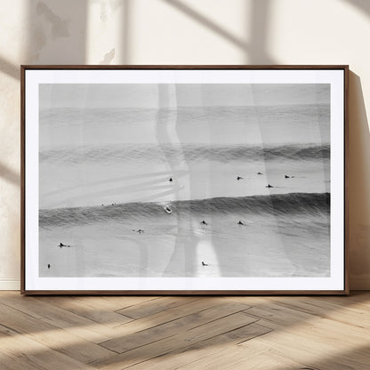 A monochrome photograph of swimmers gliding through gentle ocean waves, evoking a sense of calm and movement.