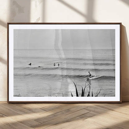 Monochrome canvas of surfers on calm ocean waves, ideal for minimalist coastal or beach-inspired interior decor.