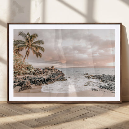 A peaceful beach scene with a palm tree and rocks, soft waves washing onto the shore under a soft pastel sky at sunset.