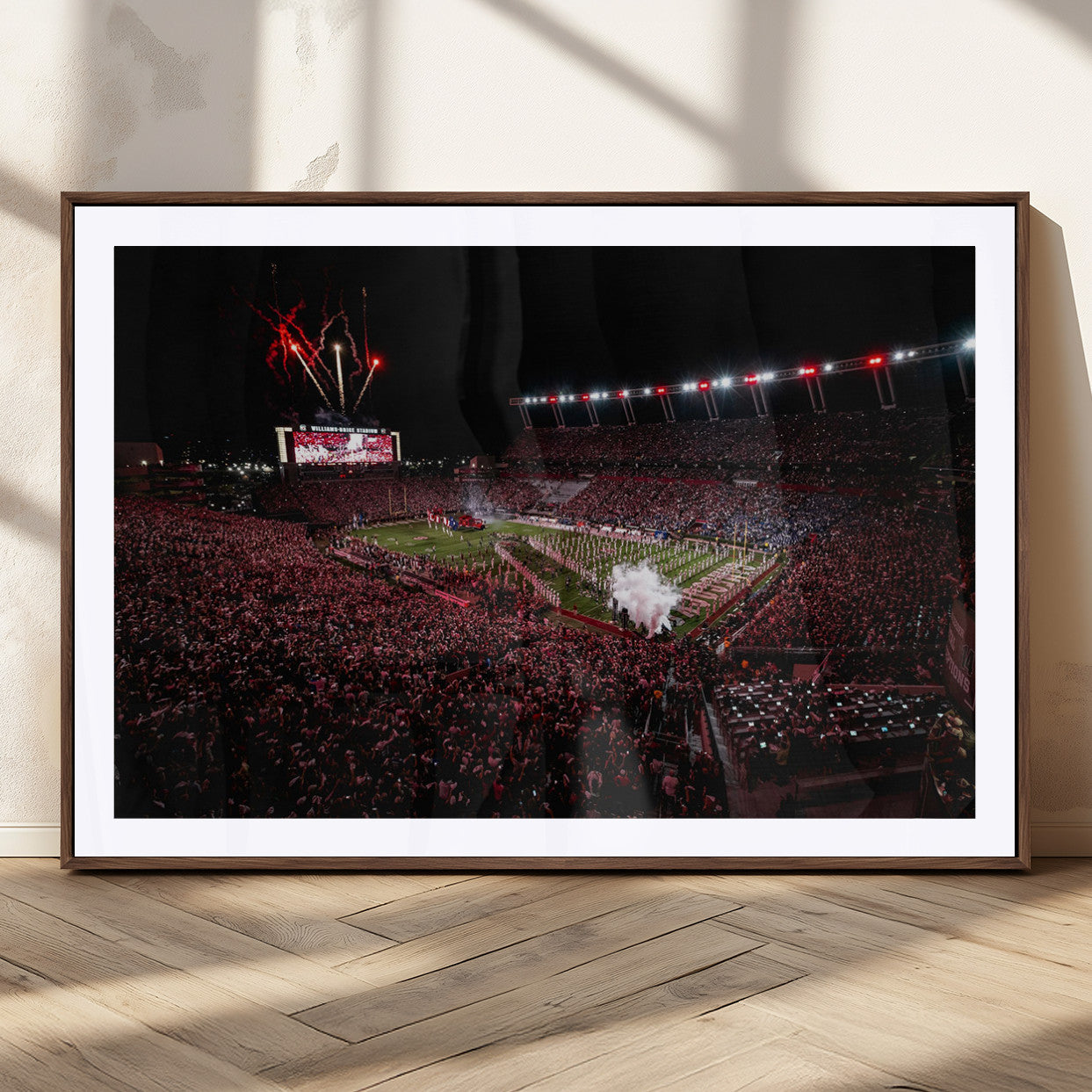 A dramatic shot of a packed stadium at night, with fireworks and smoke creating an exciting atmosphere for a live football game.