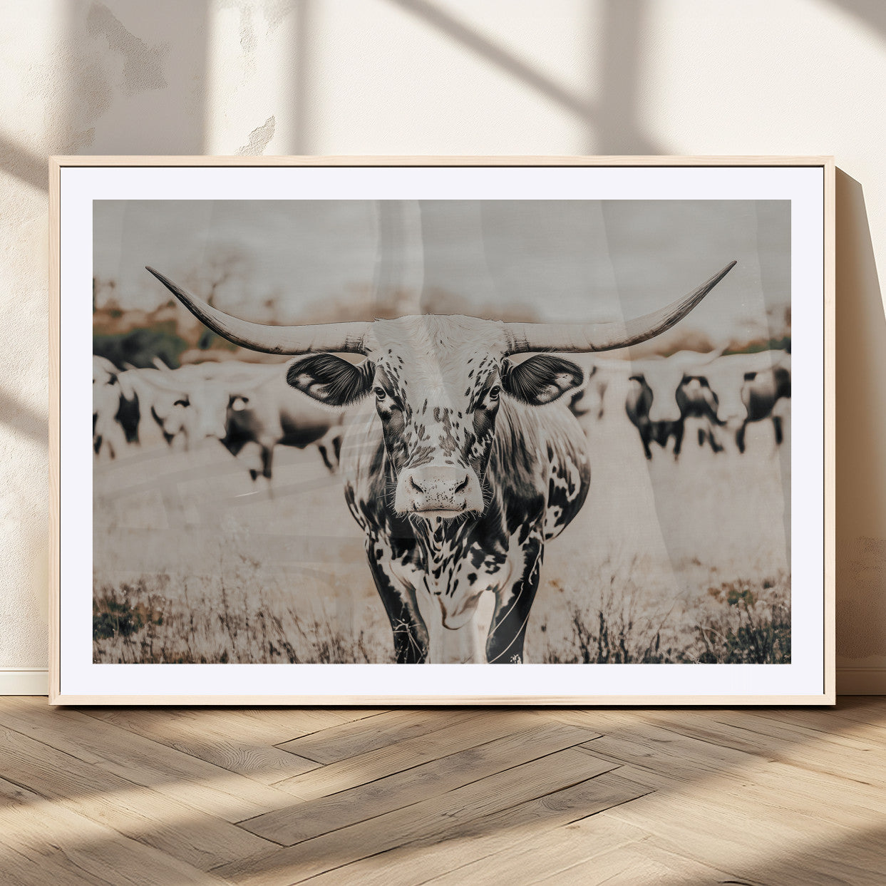 Canvas of a speckled Texas longhorn standing boldly in a field with a herd behind, perfect for rustic western or farmhouse wall decor.