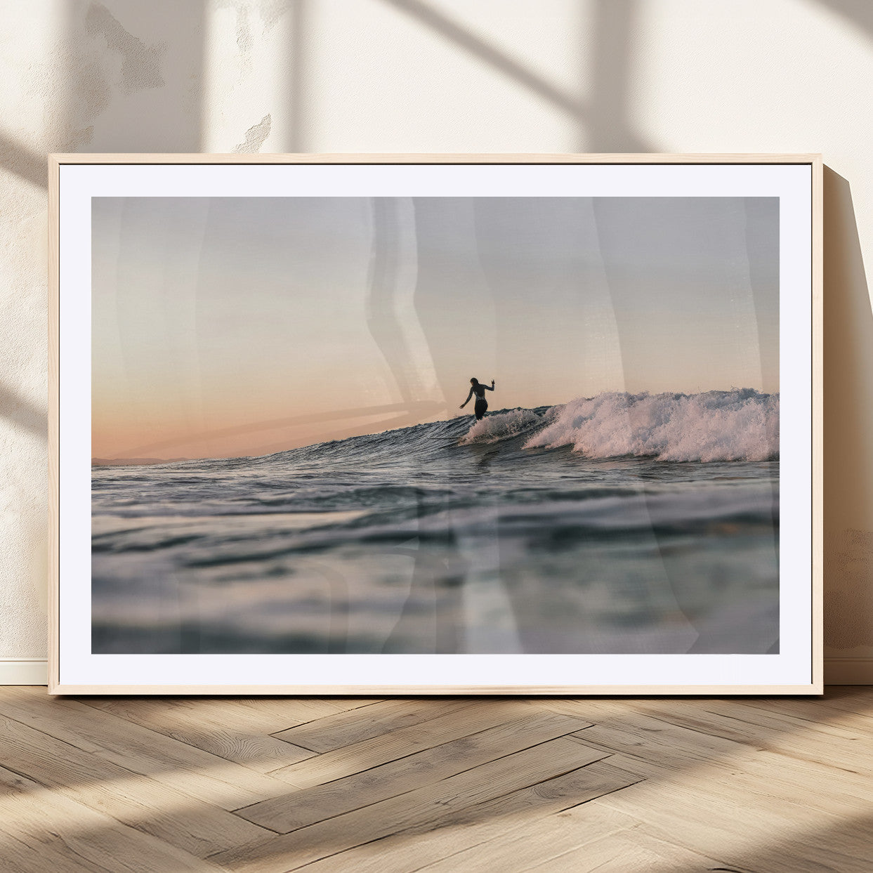 Framed canvas of a female surfer balancing on a wave at sunset, perfect for serene surf or ocean-inspired coastal decor.