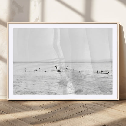 Monochrome photo of surfers riding and waiting on ocean waves, ideal for surf-themed or coastal energy wall decor.