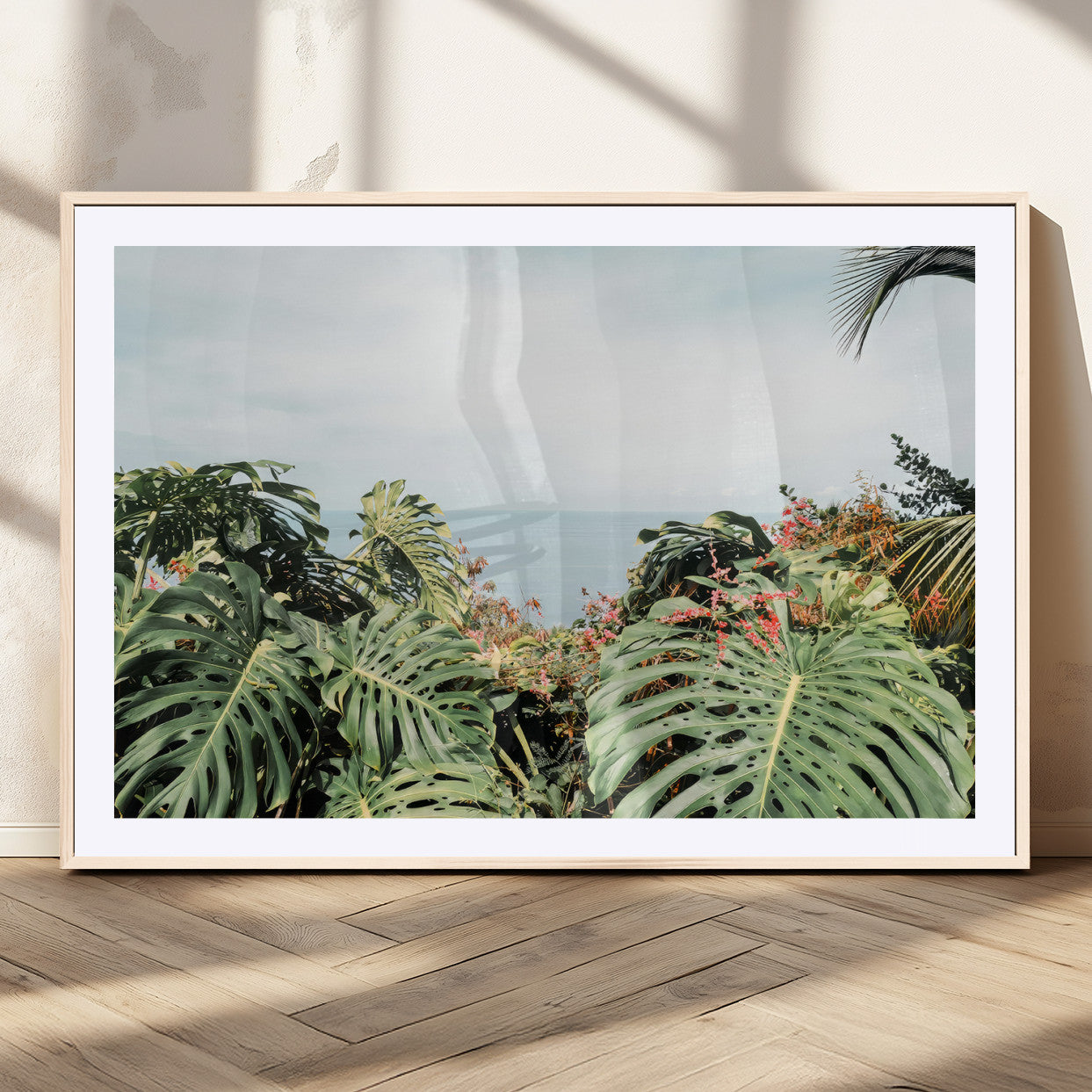 Monstera leaves and tropical flowers framing a calm ocean view, ideal for tropical coastal or exotic jungle-style interior wall decor.