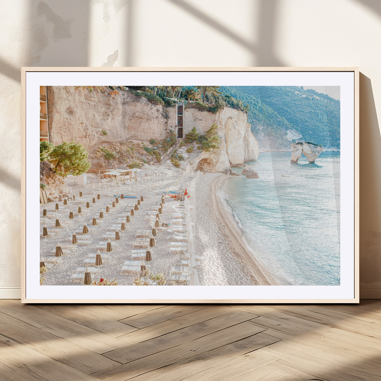 Wall art of a calm Mediterranean beach with rows of sun loungers and umbrellas in soft pastel tones, perfect for light coastal or vacation-themed decor.