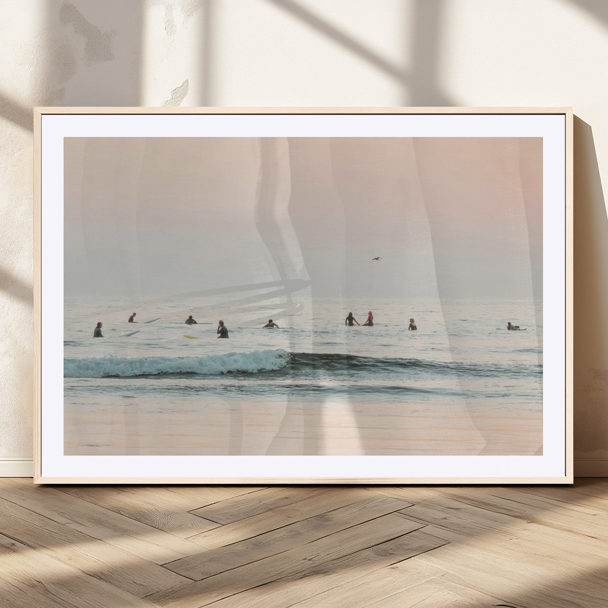 Dreamy photo of surfers waiting on soft pastel waves under a pink sunset sky, ideal for soft coastal minimalist or serene ocean-themed home decor.