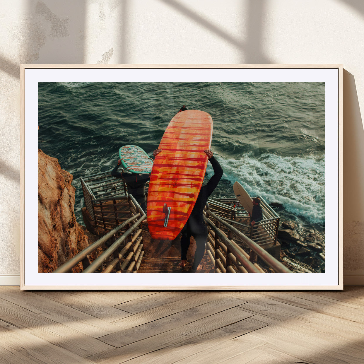 A surfer carrying a bold orange surfboard down a rugged staircase toward the ocean, bathed in golden hour light, capturing the energy of coastal adventure.