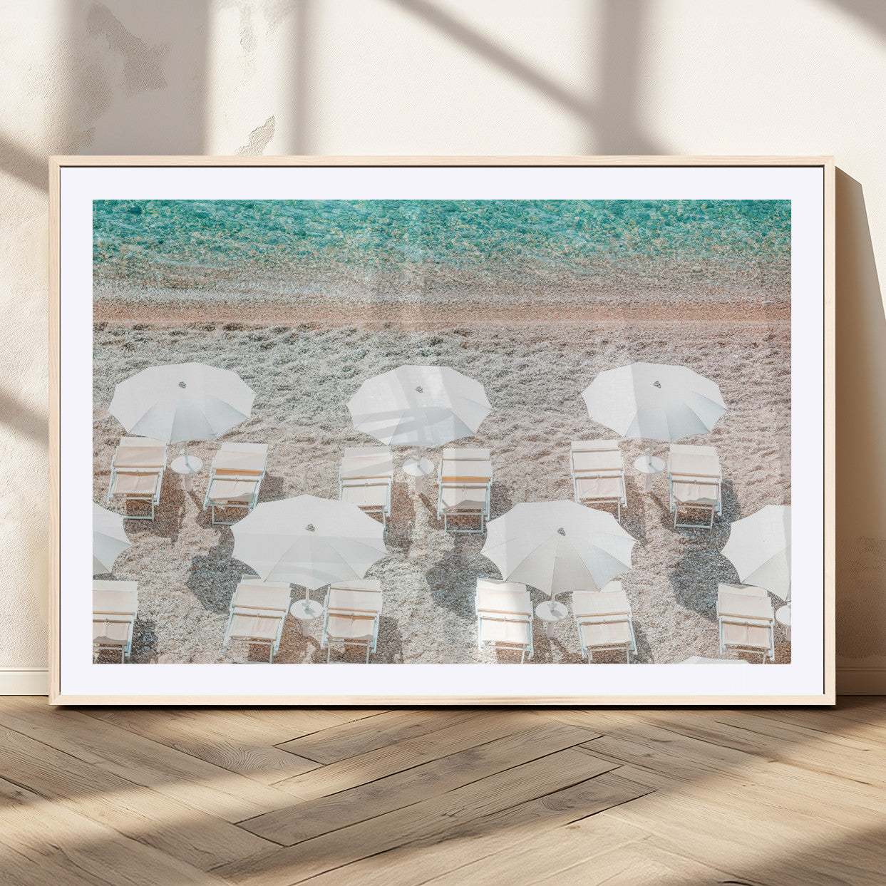 A bright beach scene with white umbrellas, pastel sand, and turquoise waters, creating a tranquil coastal vibe, perfect for beach house or summer decor.