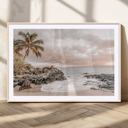 A peaceful beach scene with a palm tree and rocks, soft waves washing onto the shore under a soft pastel sky at sunset.