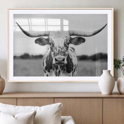Capture the strength and elegance of nature with this striking black and white portrait of a longhorn cow. Its powerful presence makes a bold statement in any room.