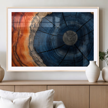 A captivating close-up of a tree trunk, showcasing its concentric rings in rich shades of blue, orange, and brown, highlighting the organic patterns of natural wood.
